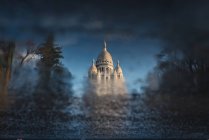 Historic cathedral building reflecting in puddle — Stock Photo