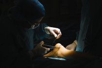 Surgeon sewing up Achilles tendon — Stock Photo