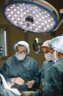 Команда хірургів, дивлячись на пацієнта — стокове фото