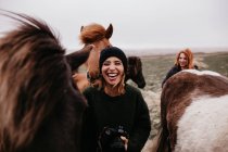 Смеющиеся женщины с лошадьми — стоковое фото