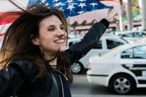 Menina bonita com bandeira da América no estacionamento — Fotografia de Stock