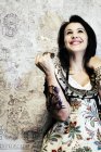 Tattooed woman smiling and posing with snake. — Stock Photo