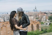 Suave pareja lesbiana en el paisaje urbano - foto de stock