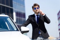 Homme d'affaires élégant avec voiture à l'extérieur — Photo de stock