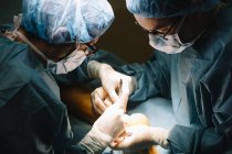 Dois cirurgiões enquanto operavam o paciente — Fotografia de Stock