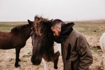 Homem apoiado no cavalo — Fotografia de Stock
