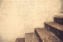 Vista de imagem cortada de passos de granito gasto e parede de azulejos — Fotografia de Stock