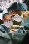 Two surgeons while operating patient — Stock Photo