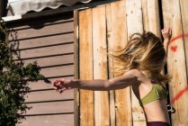 Mädchen schüttelt Haare gegen Wand — Stockfoto
