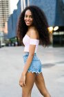 Smiling curly woman posing in street — Stock Photo
