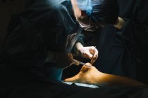Хірург у масці, робить операцію ахіллове сухожилля — стокове фото