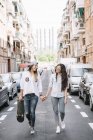 Girlfriends walking and holding hands — Stock Photo