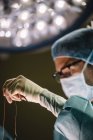 Cirujanos mano con aguja e hilo - foto de stock