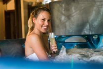 Девушка пьет шампанское в джакузи — стоковое фото