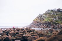 Man standing on shore boulders — Stock Photo