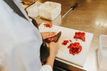 Cooks hands slicing meat — Stock Photo