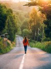 Girl walking along countryside road — Stock Photo