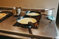 Pans with frying pancackes — Stock Photo