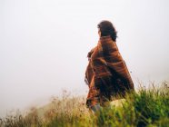 Menina em cobertor contra do céu nebuloso — Fotografia de Stock