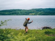 Boy throwing stone in water — Stock Photo