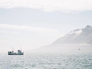 Barca galleggiante nel mare nebbioso — Foto stock