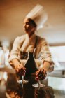 Cozinheiro fêmea segurando óculos para sobremesa — Fotografia de Stock