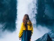 Girl standing over waterfall — Stock Photo