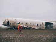 Femme contre vieille épave d'avion — Photo de stock