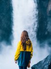 Girl standing against waterfal — Stock Photo