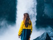 Girl looking aside against waterfal — Stock Photo