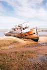 Antiguo barco oxidado costa encallada - foto de stock