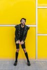 Rindo homem de moda sobre a parede amarela — Fotografia de Stock