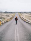 Donna che cammina sulla strada nel deserto — Foto stock