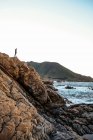 Чоловік стоїть на скелі біля моря — стокове фото