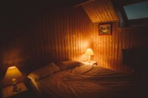 Інтер'єр спальні з палаючими лампами — стокове фото