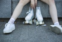 Crop girl en zapatillas con patines - foto de stock