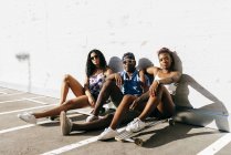 Drei Jugendliche mit Brettern auf Straße — Stockfoto