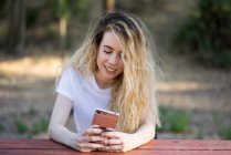Chica con smartphone en la naturaleza - foto de stock