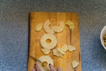 Erntefrau schneidet Ananas — Stockfoto