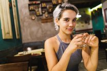 Молода жінка з випивкою в барі — стокове фото