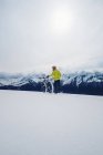 Hombre con bicicleta sobre montañas de invierno - foto de stock