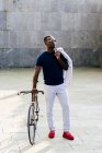 Модный чёрный мужчина с велосипедом — стоковое фото