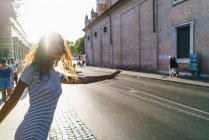 Girl hitchhiking on street road — Stock Photo