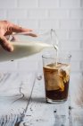 Pouring milk iced coffee — Stock Photo