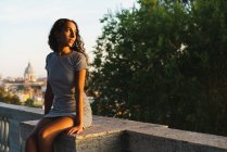 Schöne Frau sitzt auf einer Brücke — Stockfoto