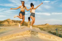 Happy women jumping on hill — Stock Photo