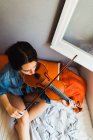 Женщина играет на скрипке в постели — стоковое фото