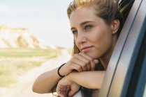 Woman looking out of car window — Stock Photo