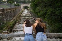 Young girls posing on bridge — Stock Photo
