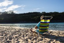 Человек, сидящий на красочном пляже кресла — стоковое фото